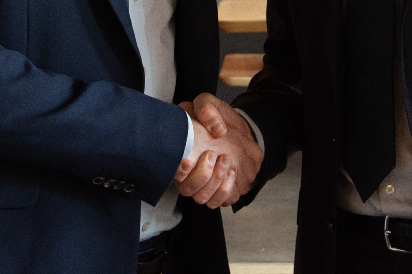 Two professionals shaking hands on a deal